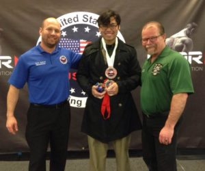 Community member powerlifts in dress clothes to overcome personal struggle, honor his identity