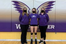 Audrey Green stands with her coaches after a volleyball game.