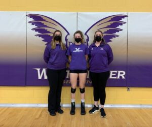 Audrey Green stands with her coaches after a volleyball game.