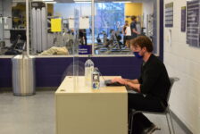 A man sits at a desk, typing on a computer.