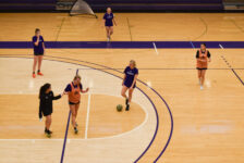 Griffin women’s soccer team players pause and talk during their off-season practice on a basketball court.