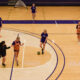 Griffin women’s soccer team players pause and talk during their off-season practice on a basketball court.