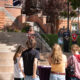 President Beth Dobkin stands behind a lectern on the stairs in front of Converse Hall while contributors to this partnership stand beside her to the right.